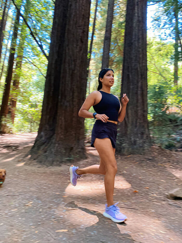 Woman running in the forest wearing Hilma Running Shoes in Purple