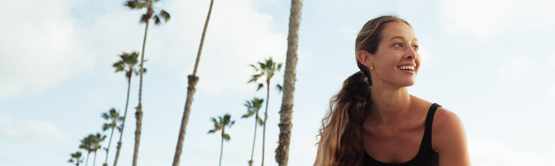 A woman with palm trees in the background