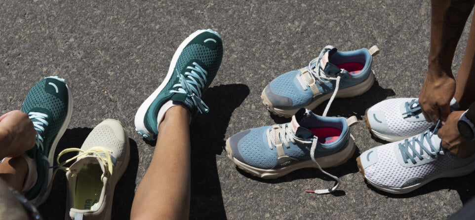 Two people putting on Hilma Running shoes