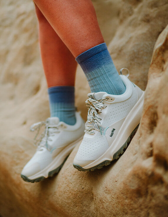 The Wildbound Trail Shoes in Snow White on a rock formation
