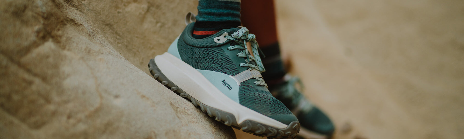 An exterior view of the Wildbound trail shoe on a rock formation