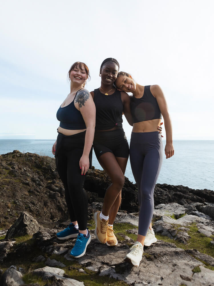 Three women standing together wearing Hilma Running shoes